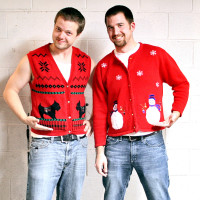 Two men wearing red holiday themed sweaters