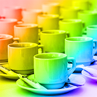 A set of coffee cups arranged on a table with the colors of the rainbow overlaid.